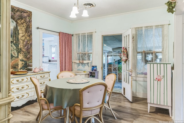 dining area featuring ornamental molding, hardwood / wood-style flooring, and a healthy amount of sunlight