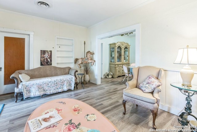 living room with hardwood / wood-style floors and ornamental molding