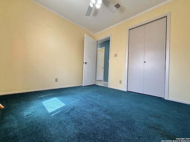 unfurnished bedroom with a textured ceiling, visible vents, crown molding, ceiling fan, and dark carpet