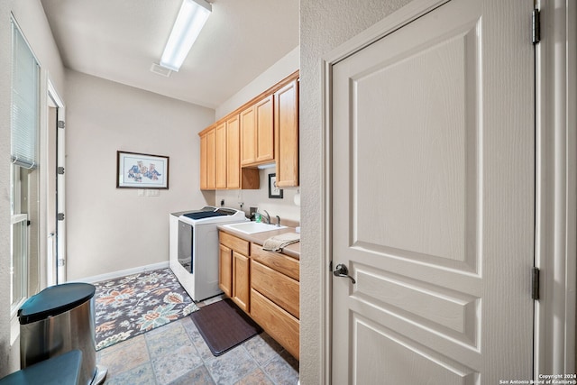 kitchen with light tile patterned floors, light brown cabinets, and washer and dryer