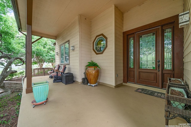 view of exterior entry featuring covered porch