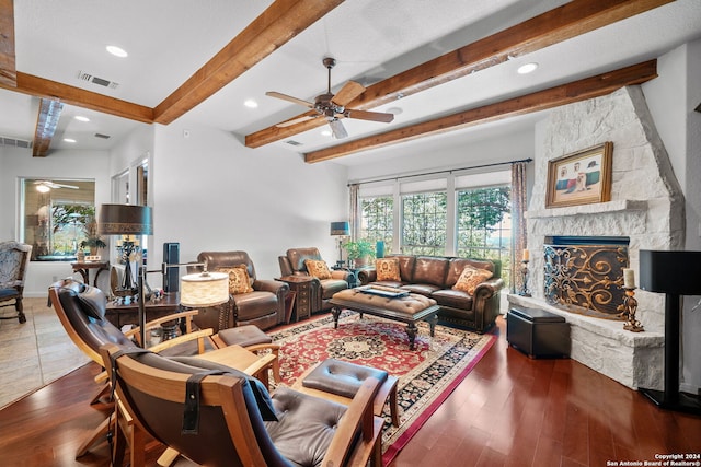 living room featuring beam ceiling, ceiling fan, hardwood / wood-style flooring, and a fireplace