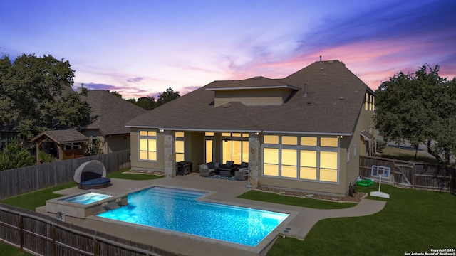 back house at dusk with a pool with hot tub, a lawn, and a patio area