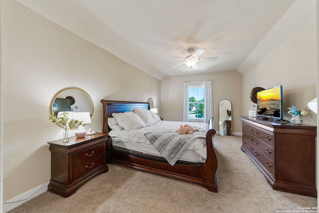 bedroom featuring ceiling fan, vaulted ceiling, and light colored carpet