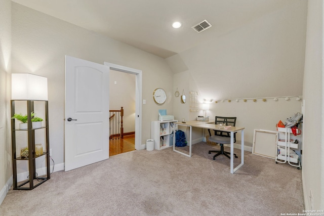 home office with light carpet and vaulted ceiling