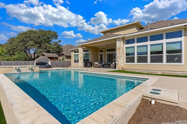 view of swimming pool featuring ceiling fan and a patio area