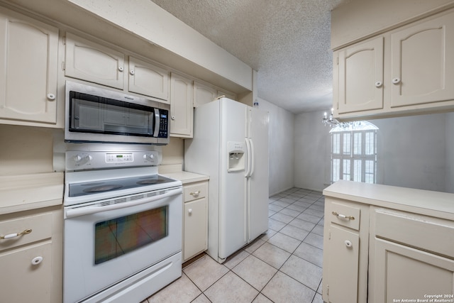 kitchen featuring a textured ceiling, light tile patterned floors, and white appliances