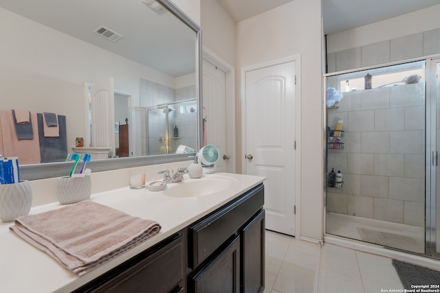 bathroom with vanity, tile patterned floors, and a shower with door