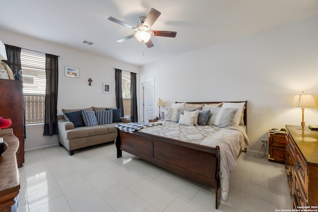 tiled bedroom with ceiling fan and multiple windows