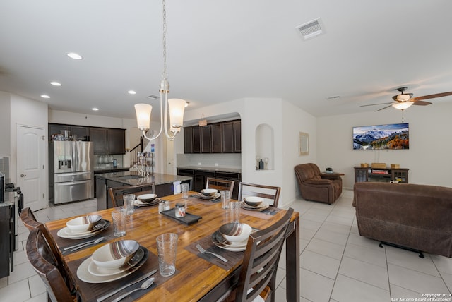 dining space with sink, ceiling fan with notable chandelier, and light tile patterned floors