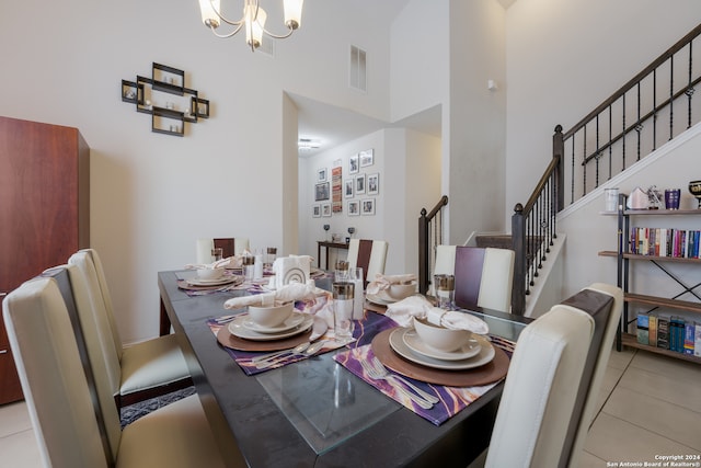 tiled dining area featuring a towering ceiling and a notable chandelier