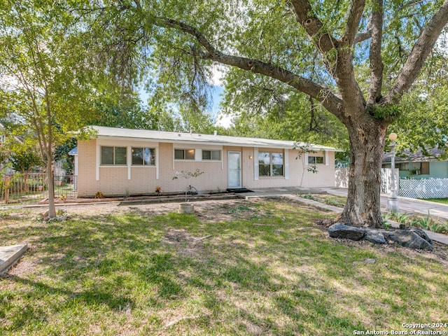 ranch-style house with a front lawn and a patio area