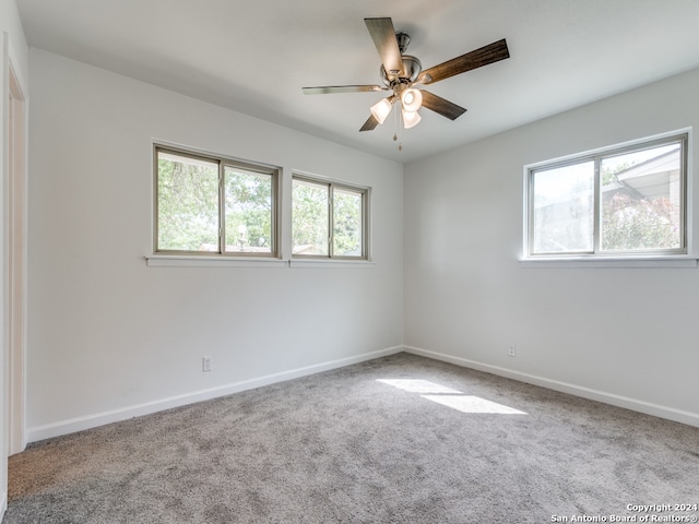 carpeted spare room with a healthy amount of sunlight and ceiling fan