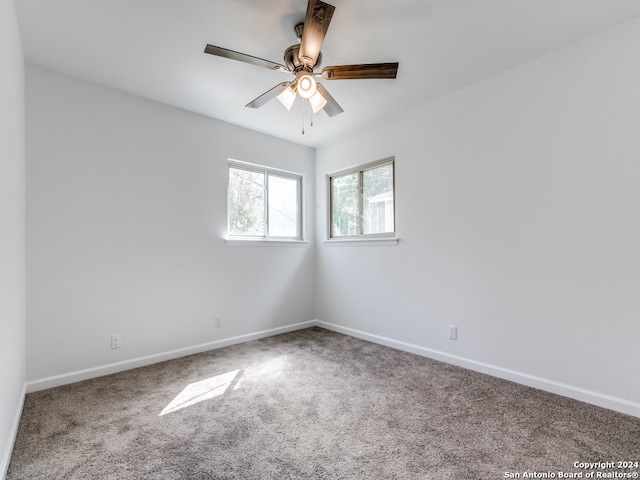 carpeted spare room with ceiling fan