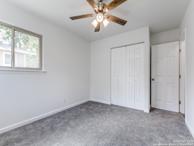 unfurnished bedroom with ceiling fan, a closet, and carpet