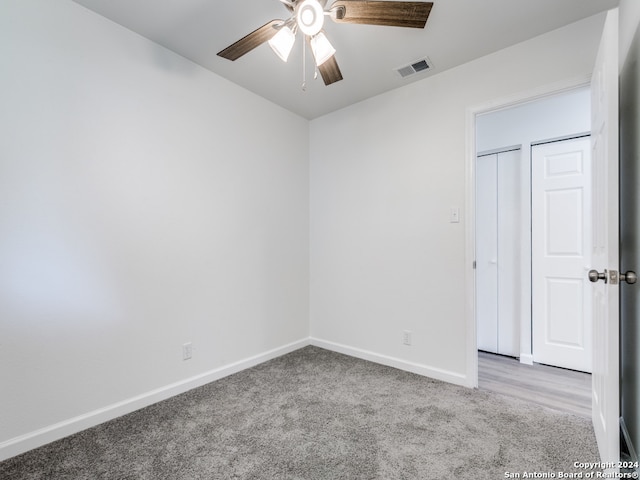 carpeted spare room with ceiling fan