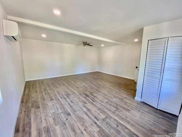 interior space featuring ceiling fan, a wall mounted AC, and wood-type flooring