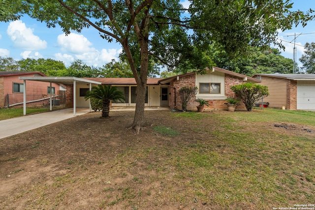 ranch-style home with a carport, a garage, and a front lawn