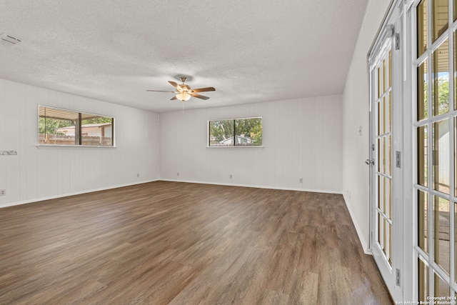 empty room featuring a textured ceiling, ceiling fan, and dark hardwood / wood-style flooring