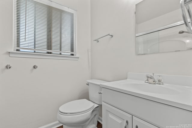 bathroom with vanity, toilet, and a shower with shower door