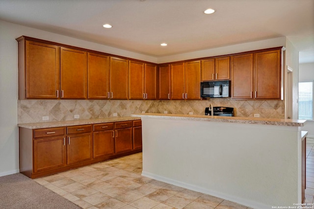 kitchen with brown cabinets, black microwave, light countertops, and electric range oven