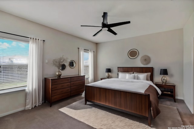 bedroom with baseboards, dark colored carpet, and a ceiling fan