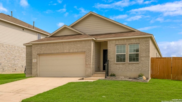 view of front of home with brick siding, a front yard, fence, a garage, and driveway