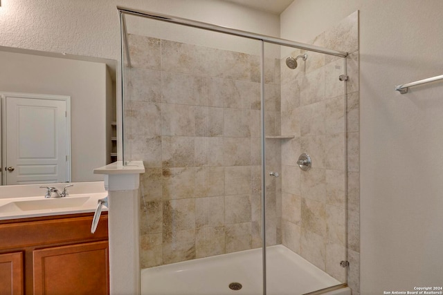 full bathroom with tiled shower and vanity