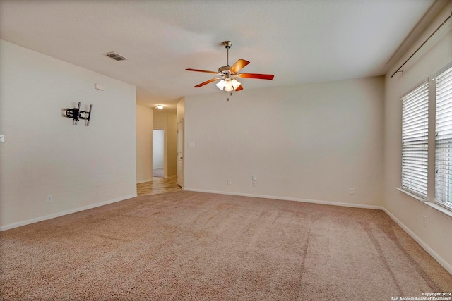 unfurnished room with ceiling fan, carpet flooring, visible vents, and baseboards