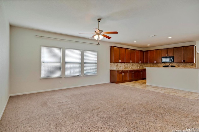 kitchen with light carpet, decorative backsplash, open floor plan, and light countertops