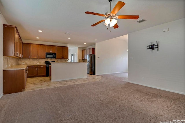 kitchen featuring black appliances, open floor plan, and light countertops