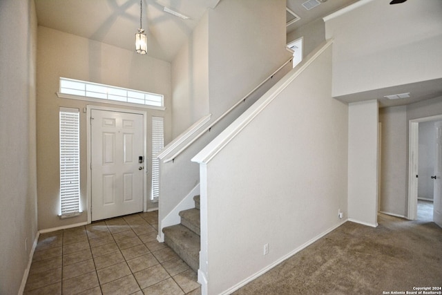 foyer with carpet flooring and a high ceiling