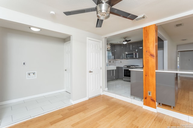 unfurnished room featuring light hardwood / wood-style floors, ceiling fan, and sink