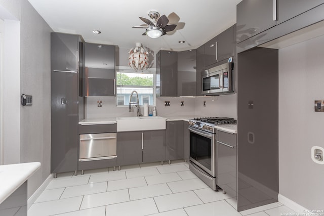 kitchen featuring sink, decorative backsplash, stainless steel appliances, light tile patterned floors, and ceiling fan