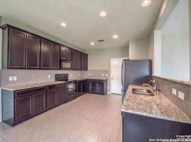 kitchen with light stone counters, sink, backsplash, black appliances, and dark brown cabinetry