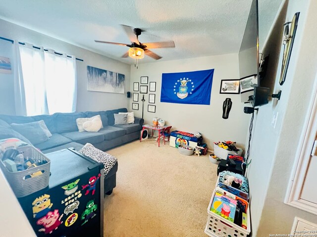 rec room featuring a textured ceiling, carpet flooring, and ceiling fan