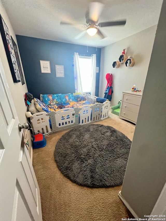 carpeted bedroom featuring a textured ceiling and ceiling fan