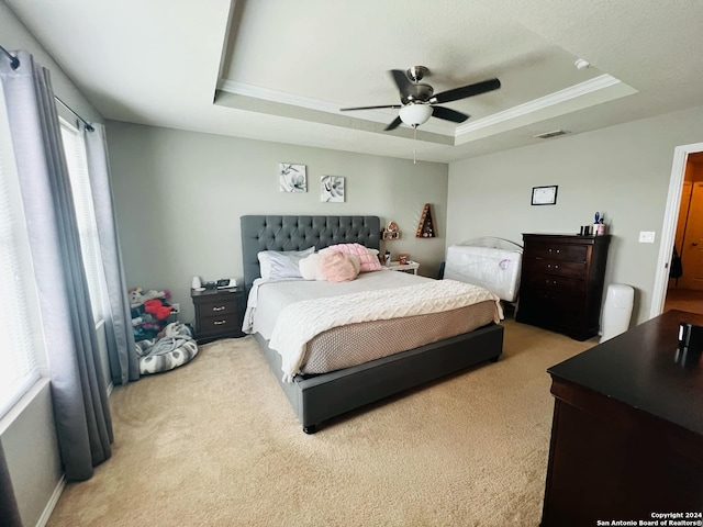 bedroom with light carpet, ceiling fan, a raised ceiling, and crown molding