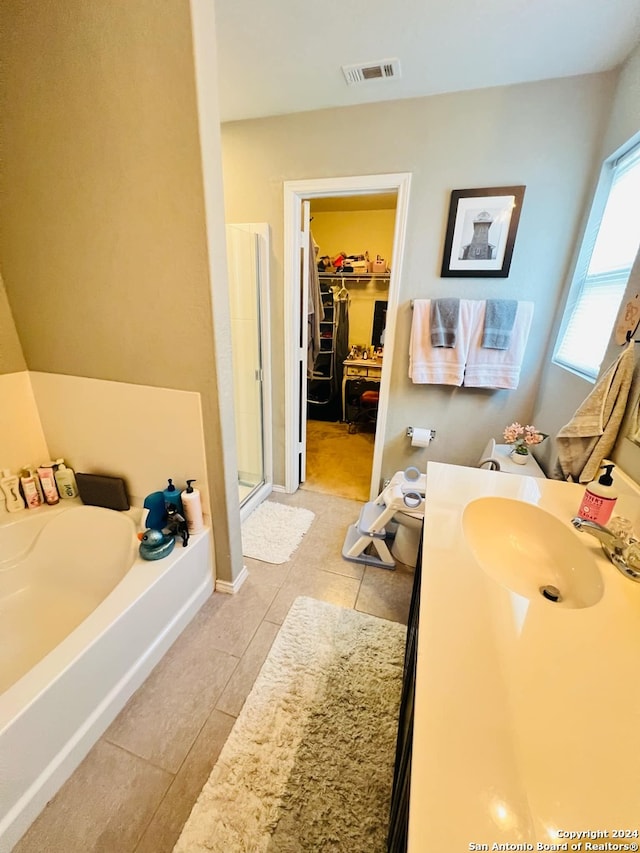 bathroom with tile patterned flooring, vanity, and separate shower and tub