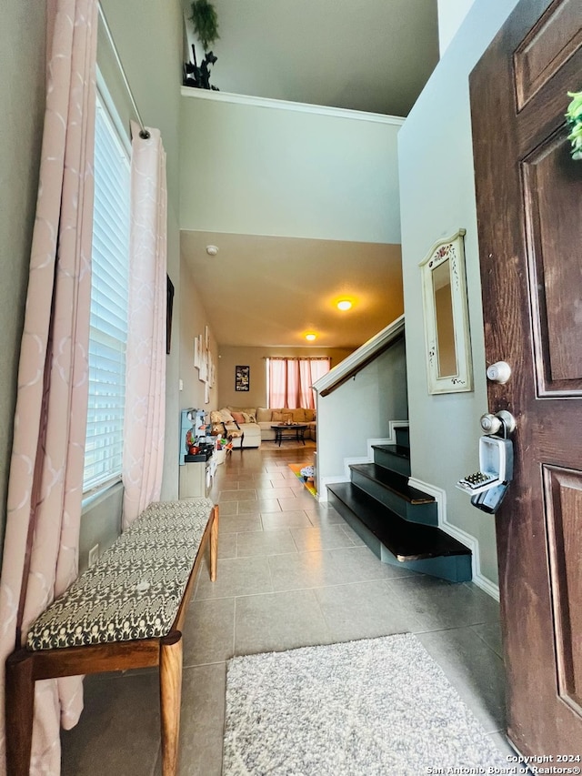 entryway featuring crown molding and light tile patterned floors