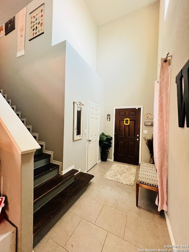 tiled foyer entrance with a towering ceiling