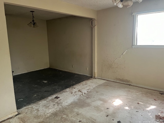 unfurnished room with a textured ceiling