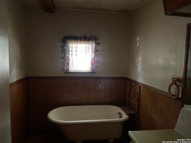 bathroom featuring a bath and wood walls