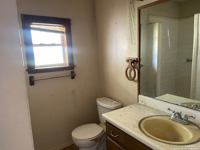 bathroom featuring tiled shower, vanity, and toilet