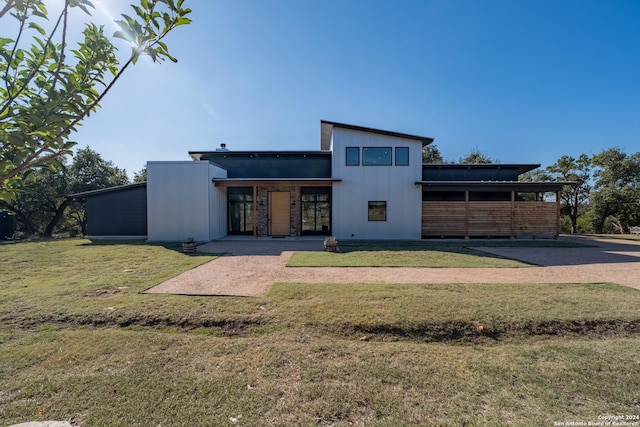 rear view of property featuring a lawn