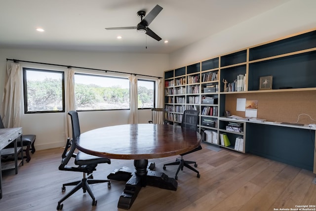 home office featuring wood-type flooring, vaulted ceiling, ceiling fan, and a healthy amount of sunlight