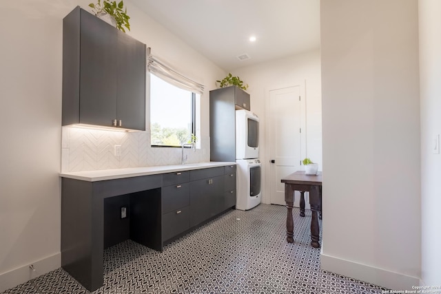 kitchen featuring stacked washer / drying machine, decorative backsplash, and sink