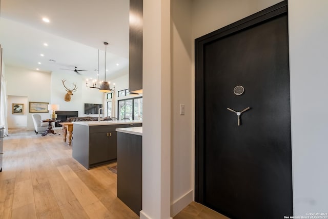 kitchen with ceiling fan, a center island, light hardwood / wood-style floors, and decorative light fixtures