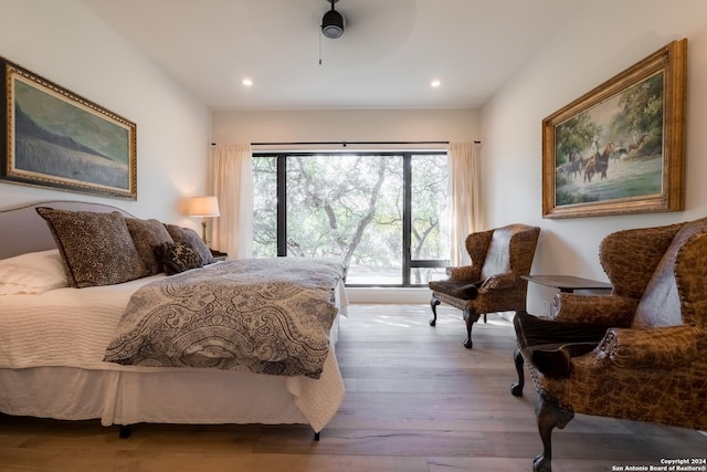 bedroom with light hardwood / wood-style flooring and ceiling fan