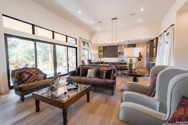 living room with an inviting chandelier, light hardwood / wood-style flooring, and plenty of natural light